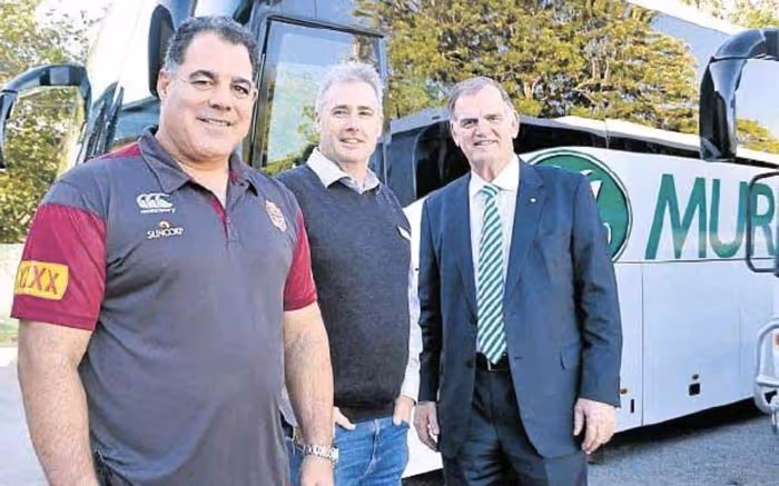 Ron Murray and Mal Meninga smiling in front of a Murrays Coach.
